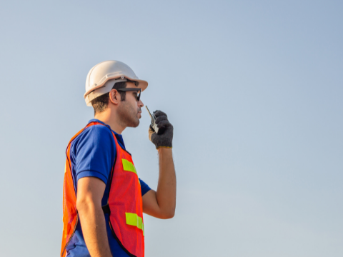 Man in hard hat using two way radio